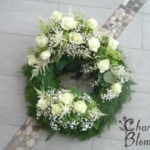 Krans med två dekorationer i vita blommor