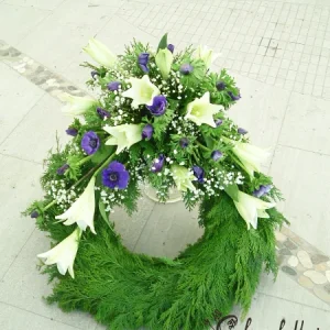 Krans med vita liljor och blå anemoner och brudslöja